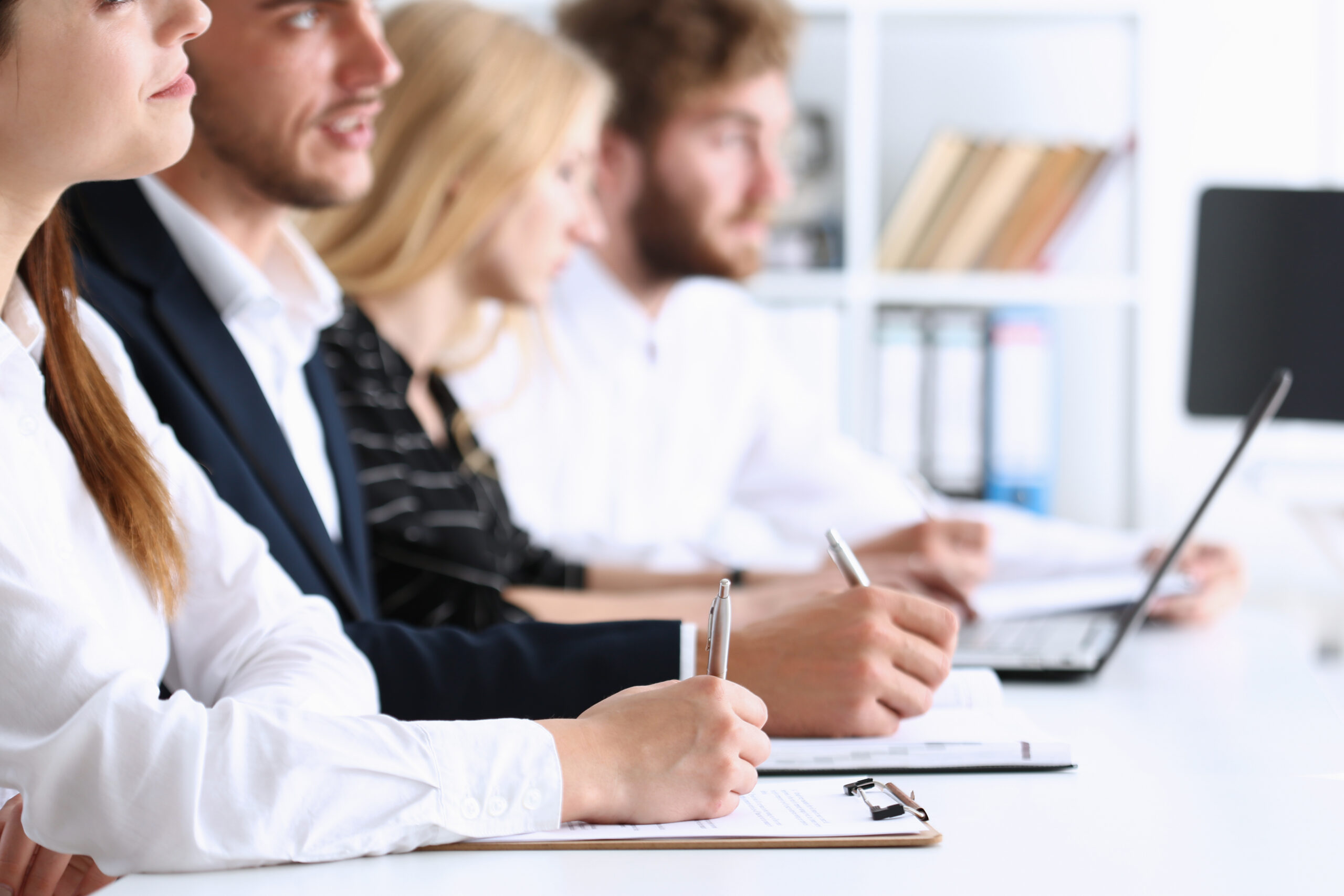 A group of people at the seminar listens attentively for good preparation and consolidation of knowledge received from the teacher make notes in notebooks and clipboards write the letter summary compiled correctly